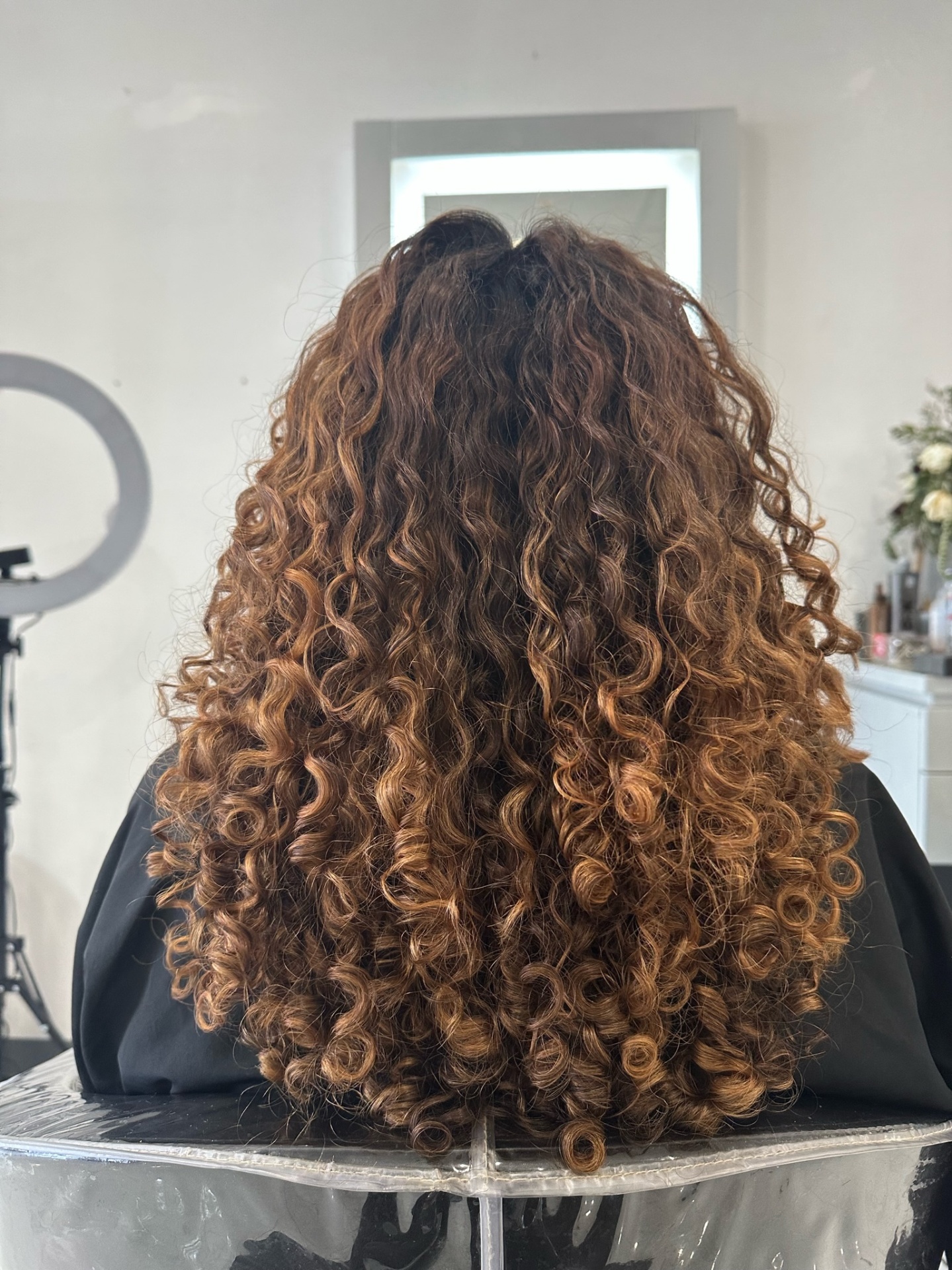 Voluminous curly hair styled with dimensional colour